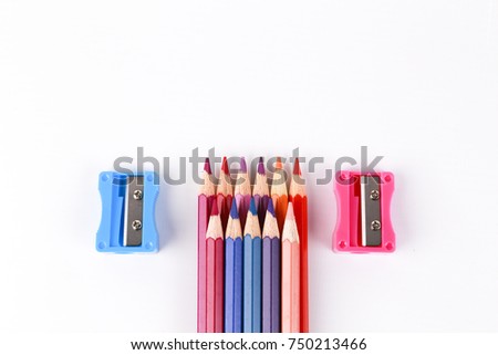 colored pencils and pencil sharpeners isolated on white background