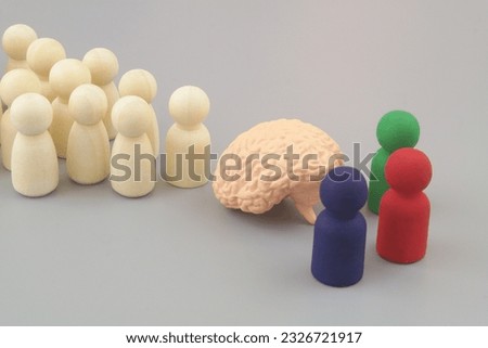 Colored people figures with human brain and ordinary wooden figures in line on gray background. Education and science concept.