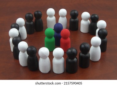 Colored people figures surrounded by black and white figures. Concept of business leadership. - Shutterstock ID 2157590405