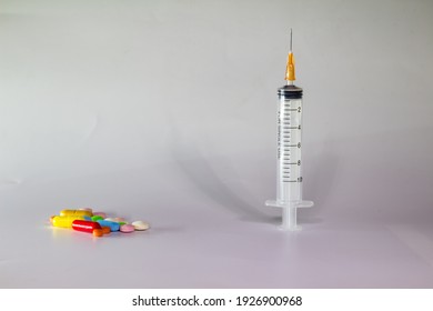 Colored Pills On A White Background With Free Space To Write. Subcutaneous Needle Syringe. Concept Of Legal Drug Use For Human.