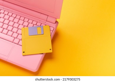 Colored PinColored Pink Laptop With Bright Floppy Disk, Modernity Concept.k Laptop With Bright Floppy Disk, Modernity Concept. High Quality Photo