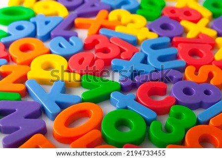 Colored plastic alphabet letters scatter closeup.