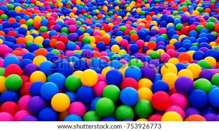 Colored plastic balls in pool of game room. Swimming pool for fun and jumping in colored plastic balls