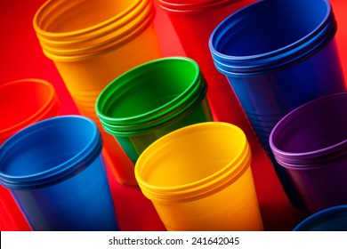 Colored plastic glasses on red background