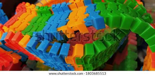 Colored plastic parts from a childrens construction\
set or a toy road. Childrens game for the development of\
imagination and fine motor skills. Red, green, yellow blue panels\
for playing with toy\
cars