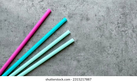 colored plastic straws for drinking on a gray background - Shutterstock ID 2315217887