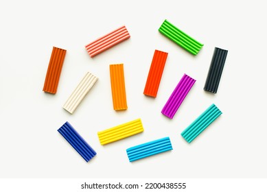 Colored plasticine on a white background. Children's plasticine. Pieces of plasticine.
