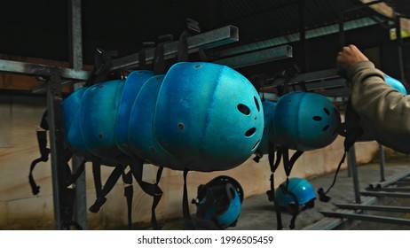 Colored protective helmets for the head to practice rafting hanging on the wall on the street
