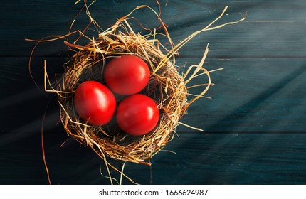 colored red Easter eggs in nest top view background, selective focus image. Happy Easter card