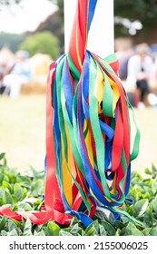 The colored ribbons hanging from the pole on a traditional English Maypole dancing day