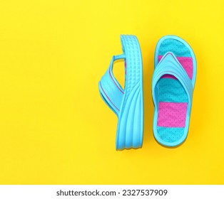 Colored slippers on a high platform on a yellow background. Shoes for the summer season. Copy space.