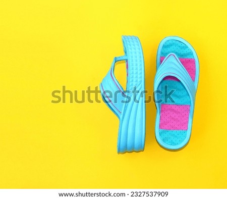 Colored slippers on a high platform on a yellow background. Comfortable shoes for the summer season. Copy space. Close-up.