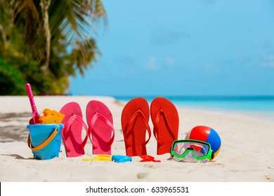 Colored slippers, toys and diving mask at beach - Shutterstock ID 633965531