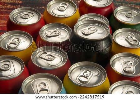 Colored soda cans for conceptual use representing that of calorie intake and obesity with a black can sticking out of the middle