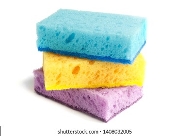 Colored sponges for washing dishes and other domestic needs. Yellow sponge lies between the blue and purple sponges at a slight angle - Shutterstock ID 1408032005