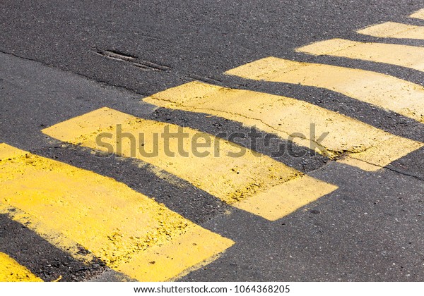 colored stripes\
artificial roughness on the road to observe the speed of cars,\
closeup of old road\
markings