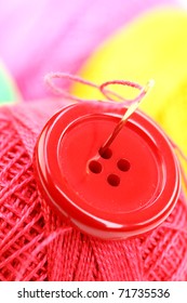 Colored thread, needles and buttons on a white background