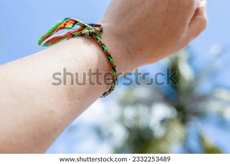 Colored thread on a woman's wrist. Sai Sin, rope tied by a monk, Thai tradition.