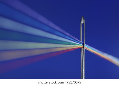 Colored threads passes through a needle's eye - symbolize refraction