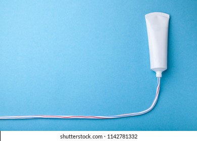 Colored Toothpaste Squeezed Out Line From Tube On Blue Background