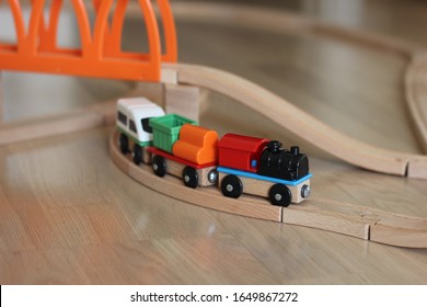 Colored toy cars on wooden rails. Early development of children. Educational toys constructor and steam engine for kids