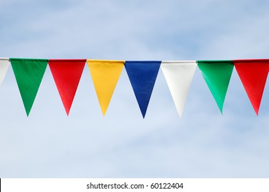 Colored triangular flags on blue sky background