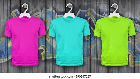 Colored T-shirts Hanging On A Wooden Wall With Graffiti