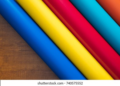 Colored vinyl rolls over wooden background