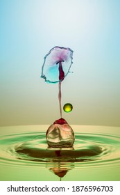 a colored water drop meets a water drop and forms an abstract shape