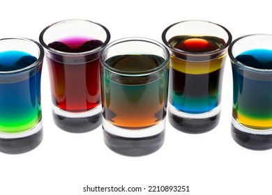 Colored Water Layers In Shot Glasses Isolated On White Background