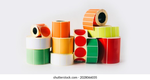 Colored and white reels with self-adhesive labels for printers - Shutterstock ID 2028066035