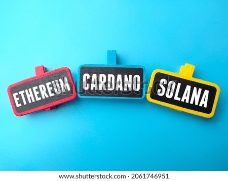 Colored wooden board written with text ETHEREUM,CARDANO,SOLANA on a blue background. Business concept.