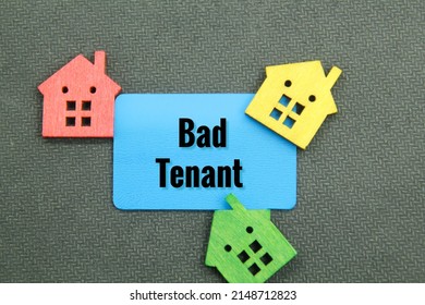 Colored Wooden Houses And Blue Paper With The Word Bad Tenant