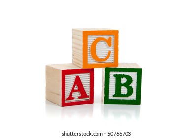 Colored Wooden Letter Blocks Including Red, Green And Yellow On A White Background With Copy Space