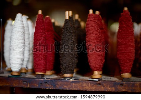 colored woolen threads on an old loom, Traditional Yarn in Canada.