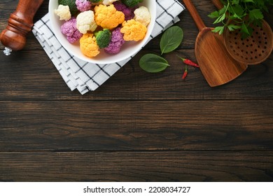 Colorfu Cauliflower. Cauliflower Cut Into Small Pieces Bowl On Old Wooden Rustic Background. Purple, Yellow, White, Green Color Cabbages. Food Cooking And Agricultural Harvest Concept Or Background.