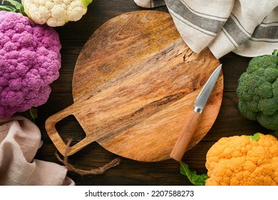 Colorfu Cauliflower. Cutting  Wooden Board And Various Sort Of Cauliflower On Old Wooden Background. Abstract Food Background. Purple, Yellow, White And Green Color Cabbages. Mock Up. Top View.