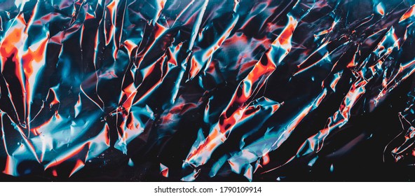 Colorful abstract background. Wrinkled texture. Blue red crumpled metallic surface.