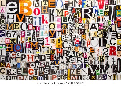 Colorful abstract collage from torn and peeling clippings with newspaper magazine letters and numbers. Alphabet letters cutting from shabby scratched paper magazine background.