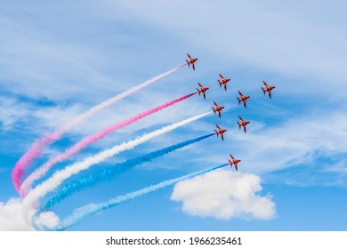 colorful acrobatic airshow of a team of pilots flying jets on formations with colorful smokes venting from the plane. - Powered by Shutterstock