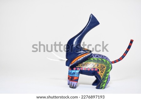 Colorful alebrije. Mexican hand painted wooden handicraft in the shape of an elephant on a white background. Oaxaca, Mexico. Copy space