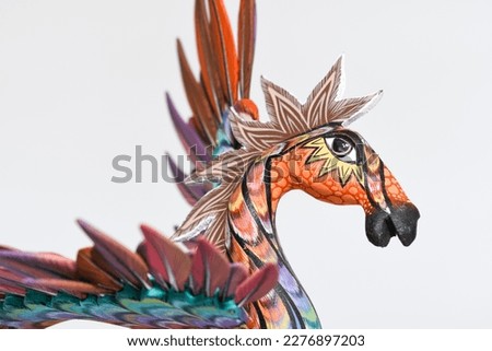 Colorful alebrije. Mexican hand painted wooden handicraft in the shape of a horse with wings on white background. Oaxaca, Mexico.