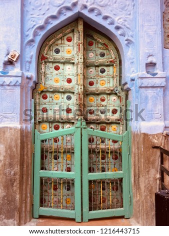 A colorful ancient door of a house add color to the blue city Jodhpur India.