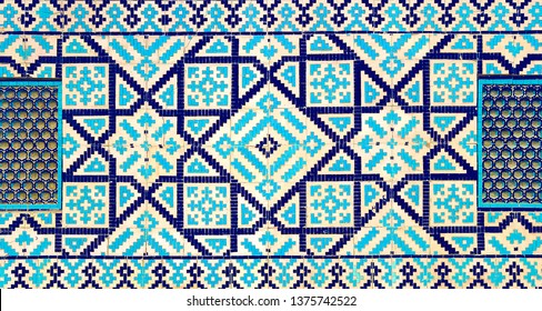 colorful ancient traditional Uzbek pattern on the ceramic tile on the wall of the mosque, abstract background