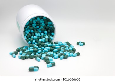 Colorful antibiotics capsule pills spread messy from plastic bottle isolated on white background with copy space.Drug resistant, infections in hospital pharmacy concept.