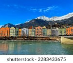 The colorful architecture of Innsbruck town with snowy mountains background in winter.