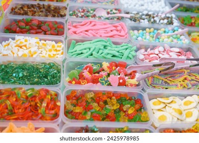 Colorful array of assorted gummy candies presented in containers, offering a variety of shapes and flavors for a sweet treat experience