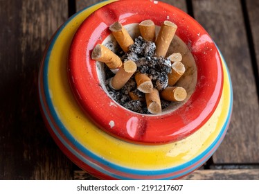 A Colorful Ashtray With Old Cigarettes With View From Above