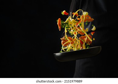 Colorful assorted seafood, vegetables, herbs and italian pasta in a pan in frozen flight on a black background. Seafood, Italian cuisine. Recipes for restaurant and home cooking. Advertising, banner. - Powered by Shutterstock