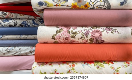 A colorful assortment of fabric rolls featuring floral patterns, solid tones, and intricate designs. Perfect for sewing projects, home decor, or creative crafting. - Powered by Shutterstock